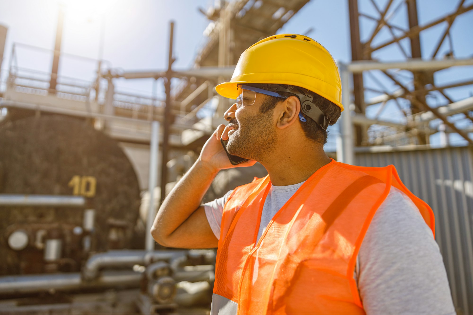 Construction engineer with using cellphone at plant